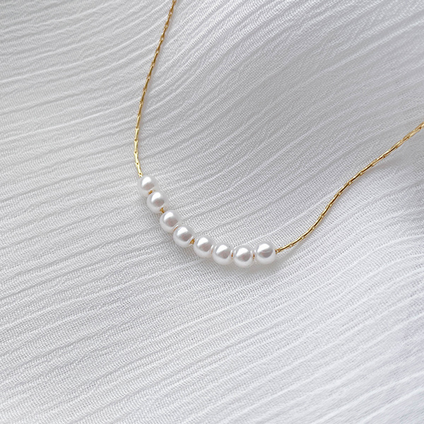 A pearl necklace that creates an antique-like, luxurious mood