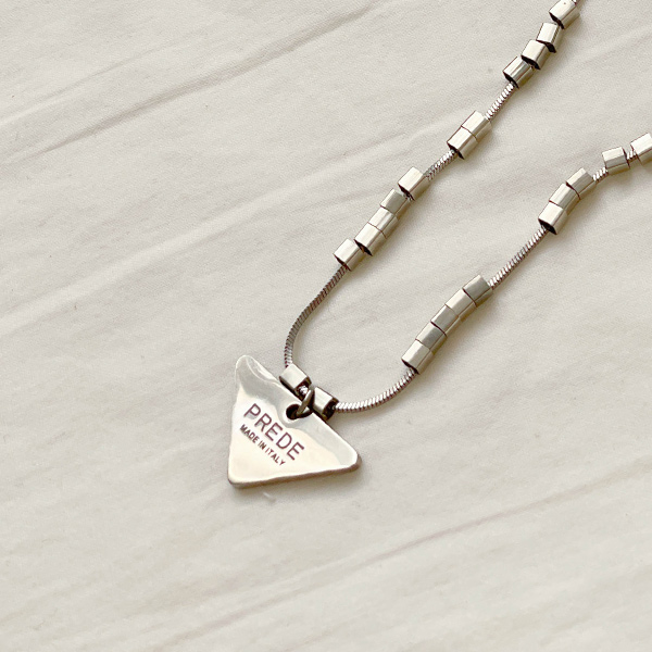 A triangular pendant necklace that creates a sophisticated and luxurious mood